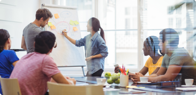 business-executives-discussing-with-their-colleagues-whiteboa